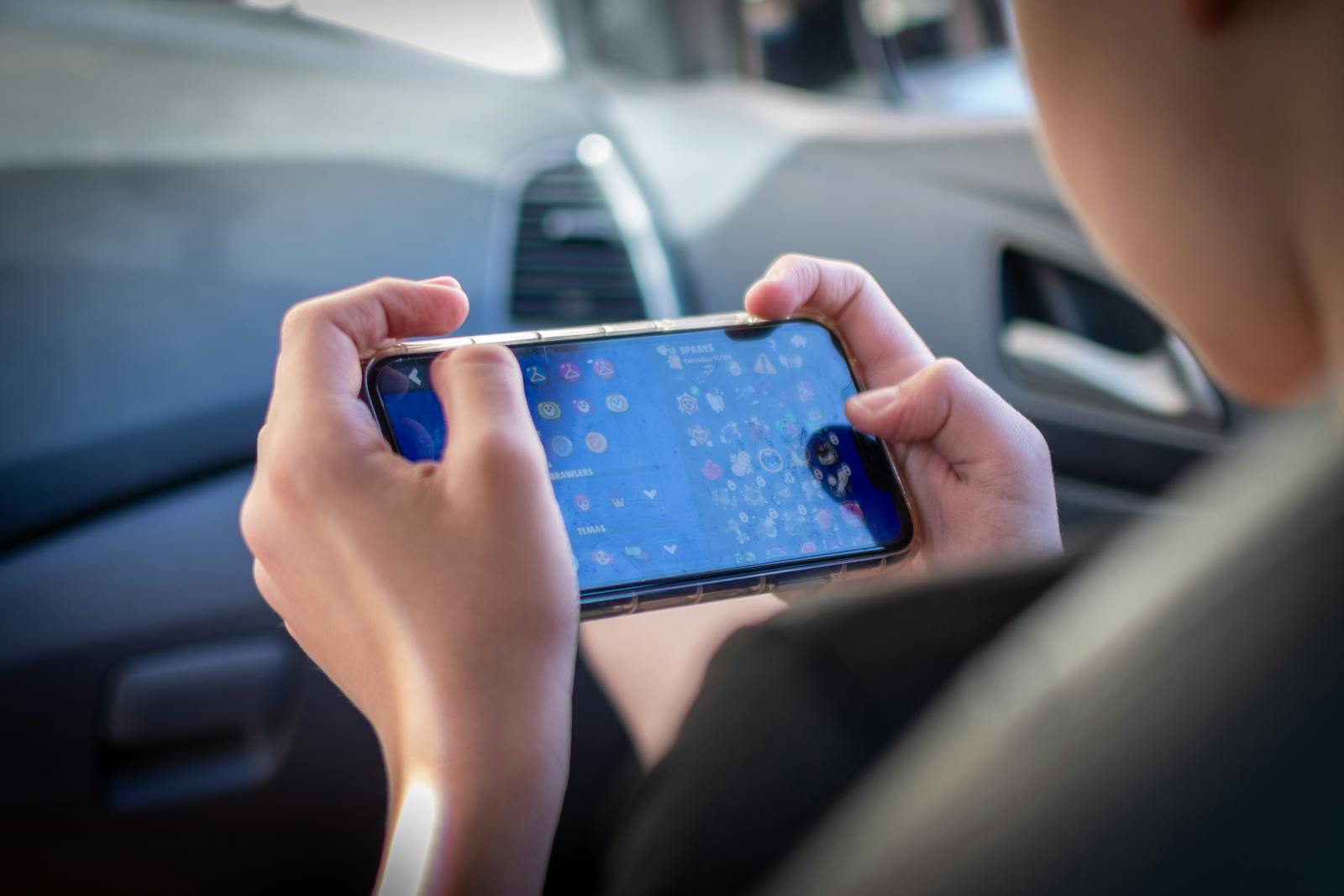 Close-up of a player checking a mobile game update while commuting through the city
